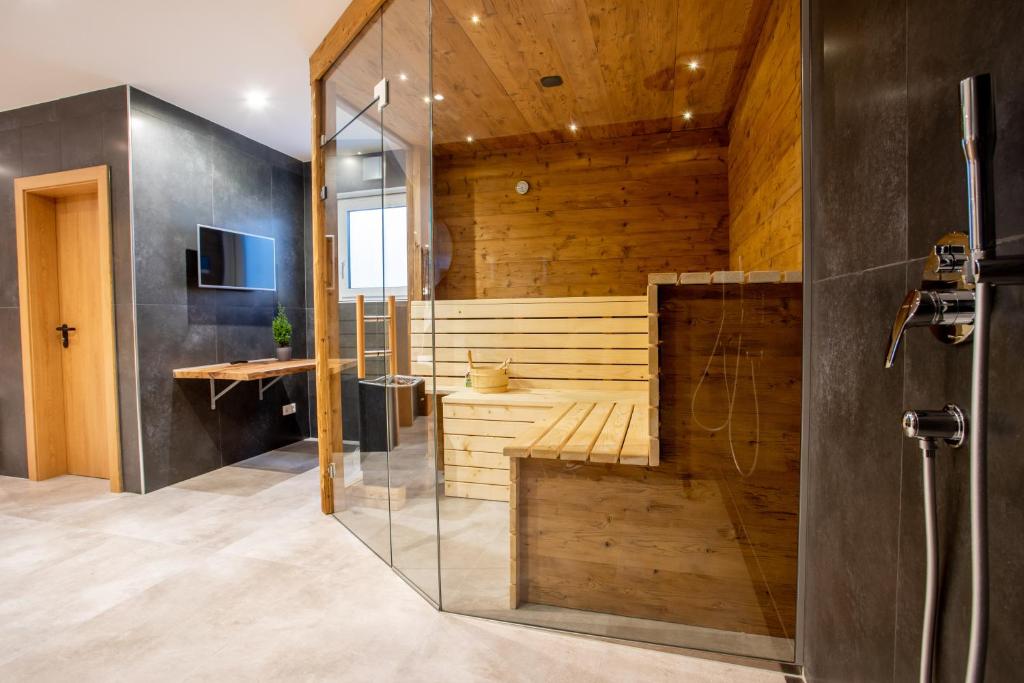 een badkamer met een sauna en een glazen deur bij Private Spa & Garden Alpi in Garmisch-Partenkirchen