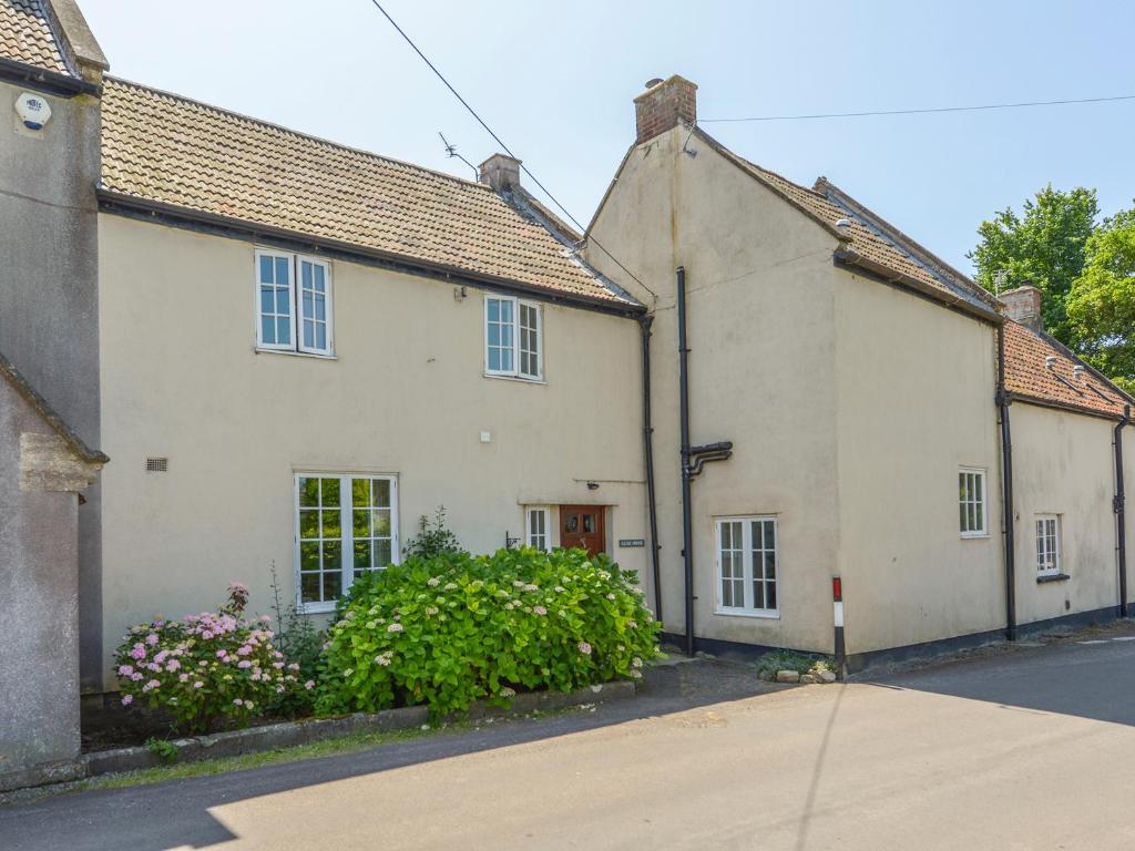 ein weißes Haus mit Blumen vor einer Straße in der Unterkunft Glebe House in Wells