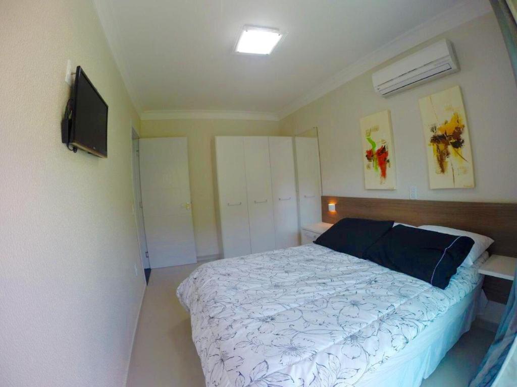 ein Schlafzimmer mit Bett und Flachbildfernseher in der Unterkunft Bombinhas Summer Beach -Apartamento Particular in Bombinhas