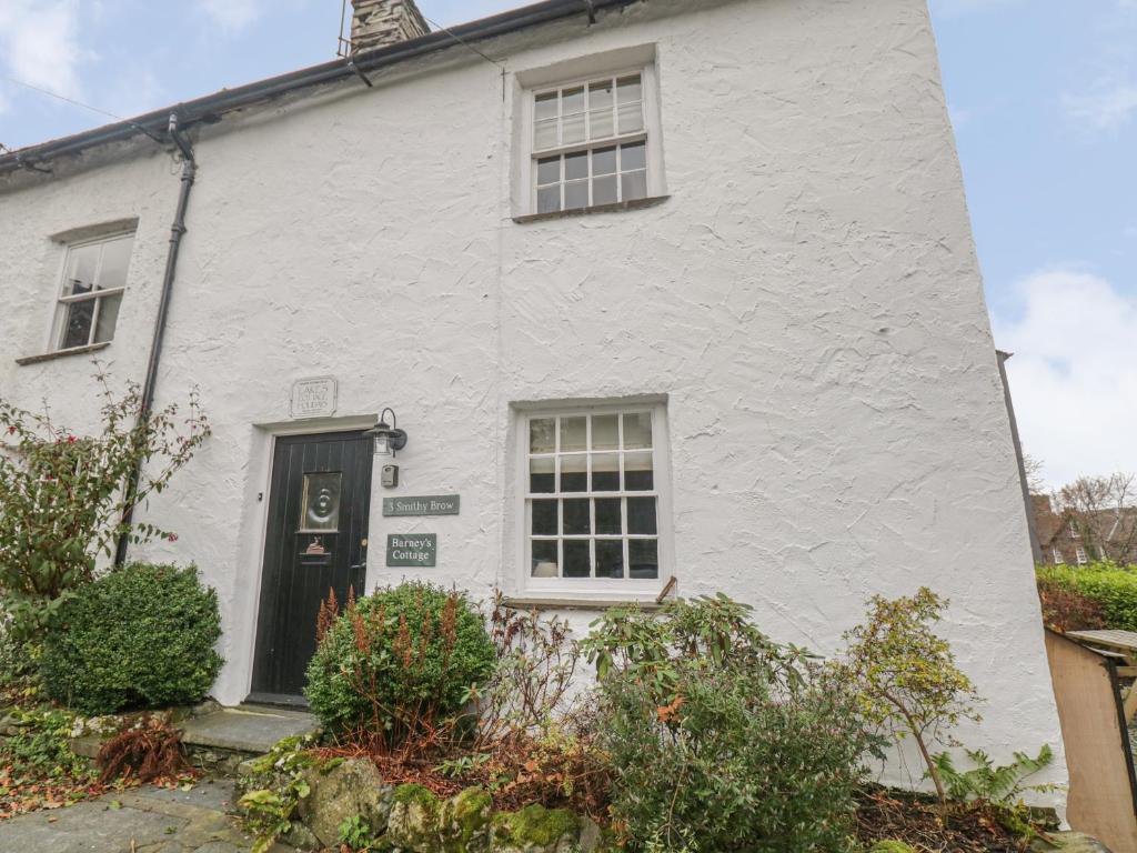 a white house with a black door at Barney's Cottage in Ambleside