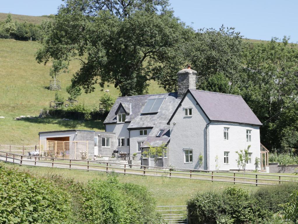 a large white house on a farm in a field at Lower Hodre in Bucknell