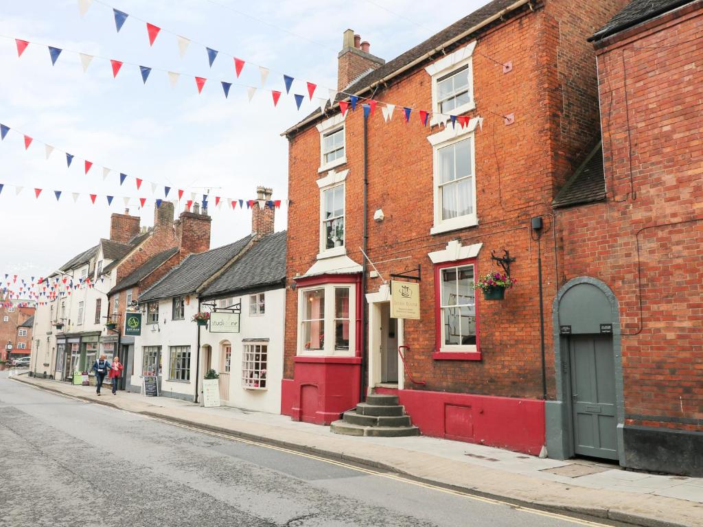 een straat met een rij huizen en vlaggen bij The Old Clock Makers in Ashbourne