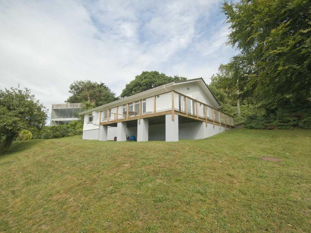 a house on a grassy field with a building at The Meadow in Feock
