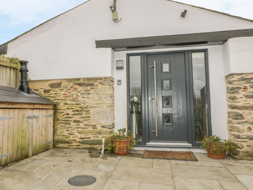 a front door of a house with a stone wall at The Bolthole in Crantock