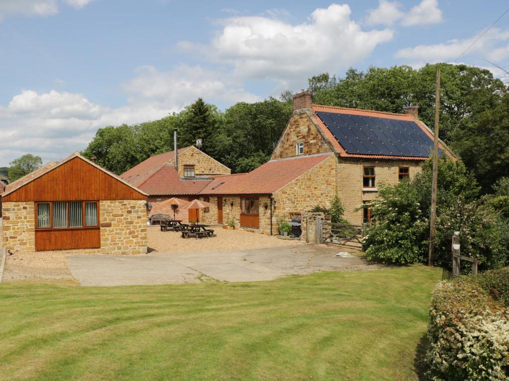 a house with solar panels on the roof at Little Byre Cottage in Sutton