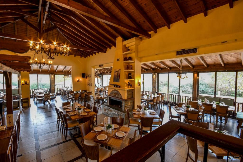 a restaurant with wooden tables and chairs and windows at Archontiko Liamas in Stavros