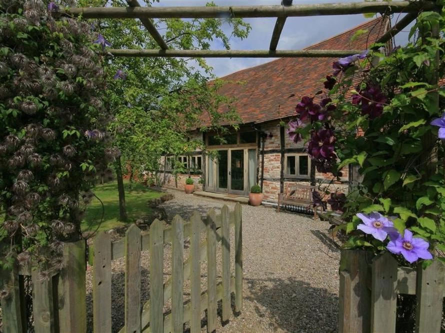 a wooden fence in front of a house at Whites Farm Barn in Ledbury