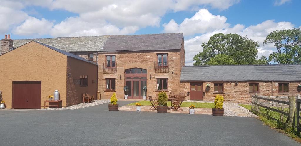 a brick house with a driveway in front of it at THE GINNEY Country Guest House in Penrith