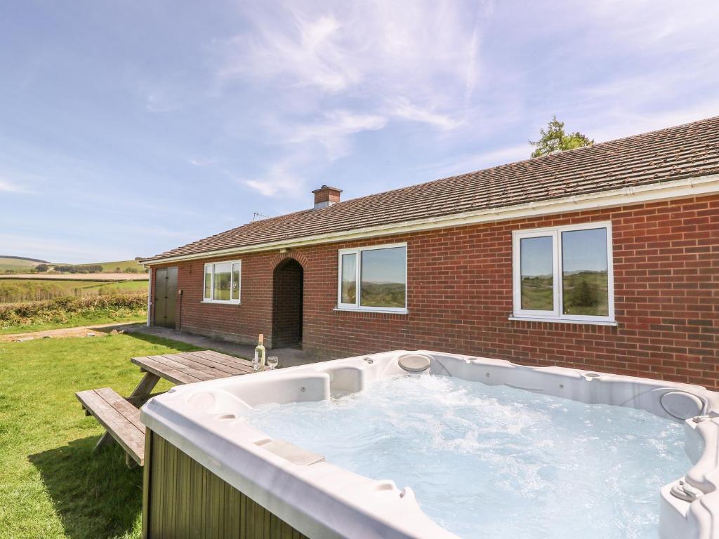 a hot tub in the backyard of a house at Glanyrafon Bungalow in Rhayader