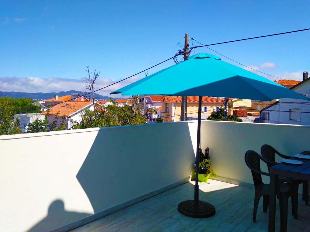 een blauwe paraplu op het dak bij Independent house near Estoril with terrace in São Domingos de Rana