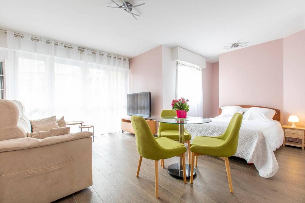 a bedroom with a bed and a table and chairs at Appartement terrasse Stella Casino centre classé 3 étoiles in Aix-les-Bains