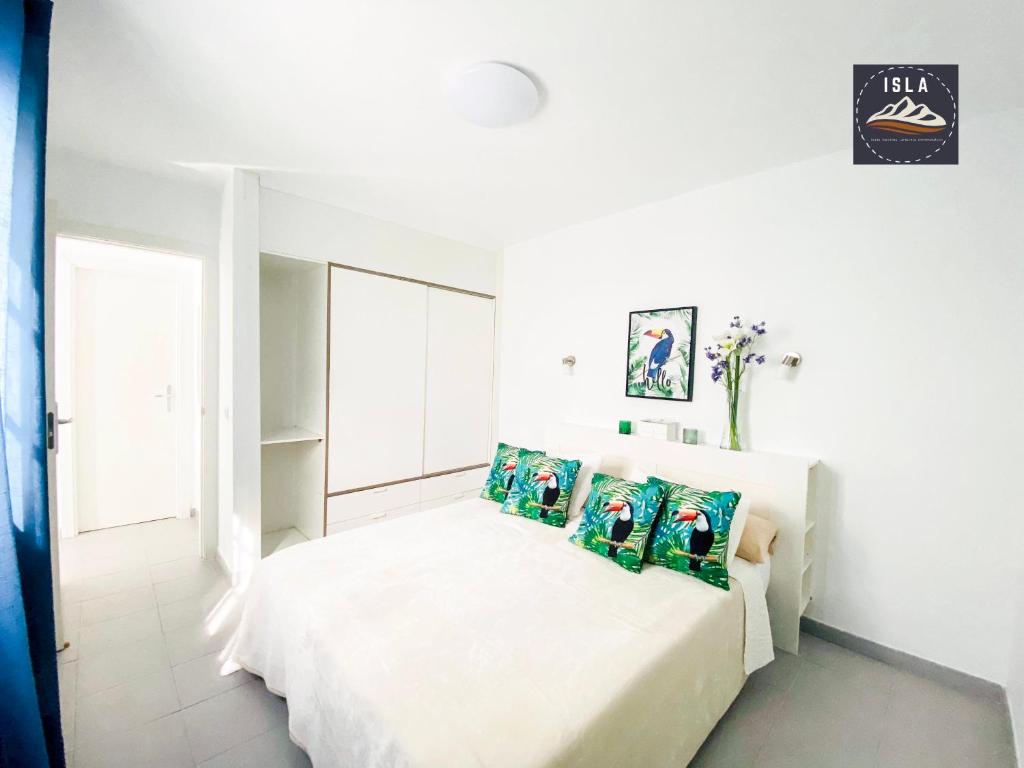 1 dormitorio blanco con 1 cama con 4 almohadas en Casa Tucán Puerto del Carmen, en Puerto del Carmen