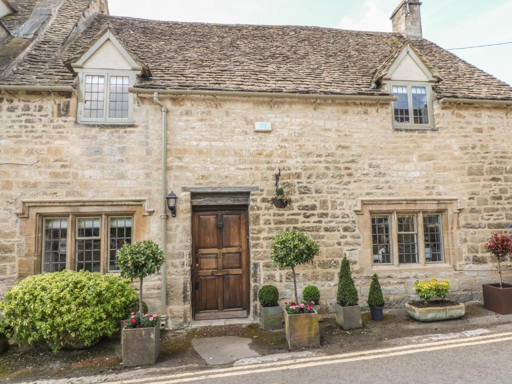 an old stone house with a wooden door at Bull Cottage in Burford