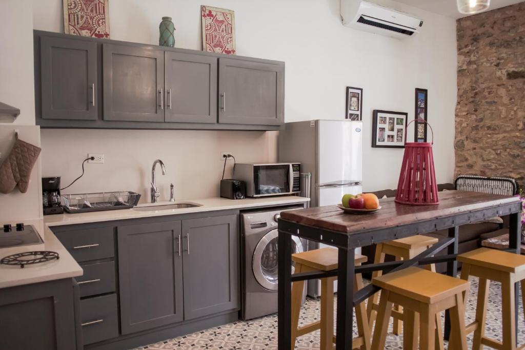 a kitchen with gray cabinets and a table with chairs at Central Apartment in Casco Viejo - View on Main Plaza in Panama City