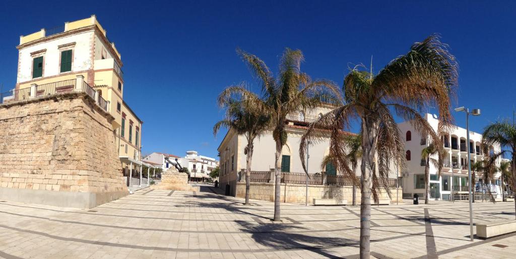 budynek z palmami przed nim w obiekcie Casa Anna & Bruna w mieście Marina di Ragusa
