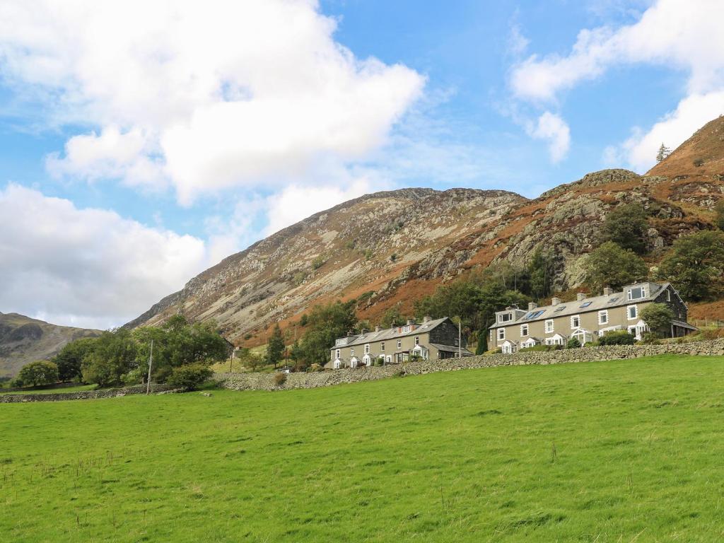 a group of houses in a field in front of a mountain at Fellview in Glenridding