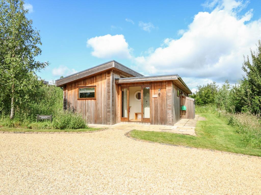 ein kleines Holzhaus mit Kieseinfahrt in der Unterkunft Burley in Cottesmore