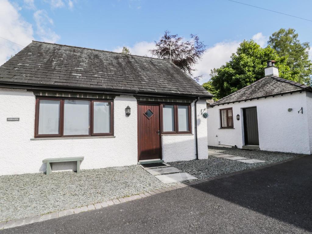 ein weißes Haus mit einer Tür und einer Bank davor in der Unterkunft Gerand in Windermere
