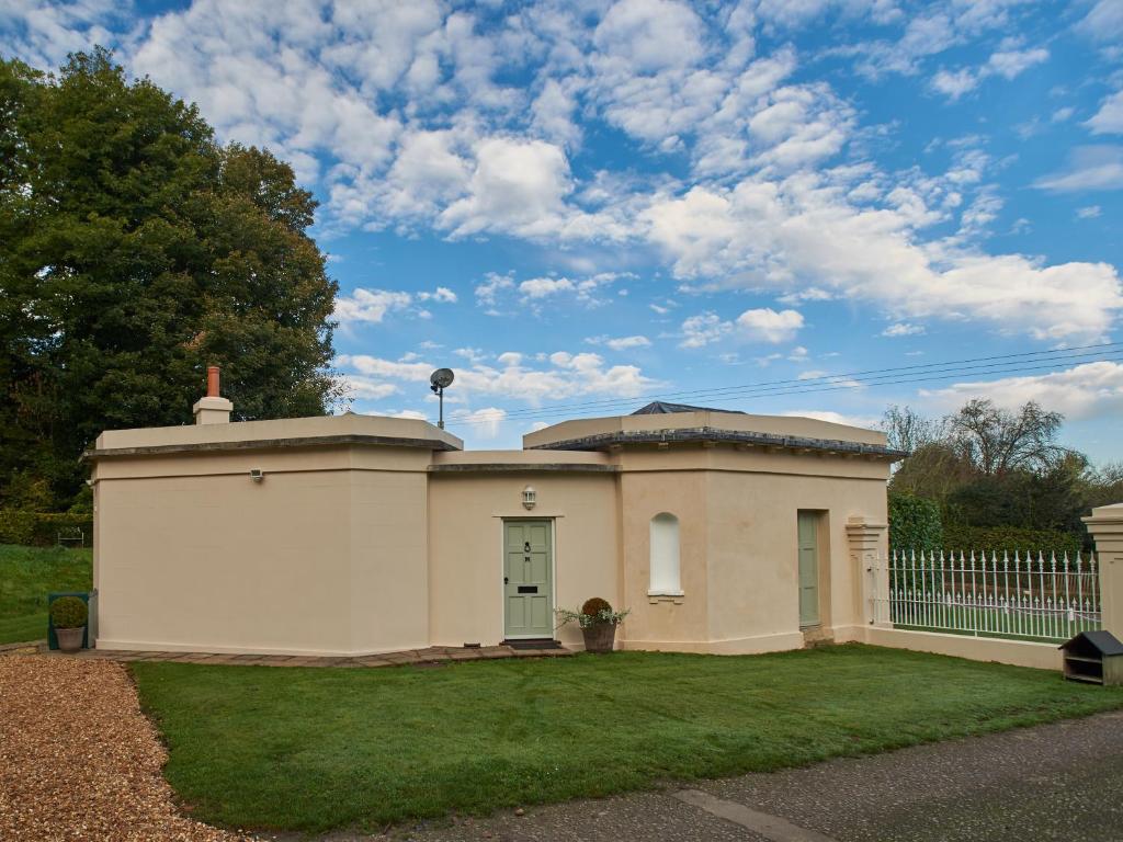 una pequeña casa blanca con una valla en un patio en West Lodge en Rockbourne