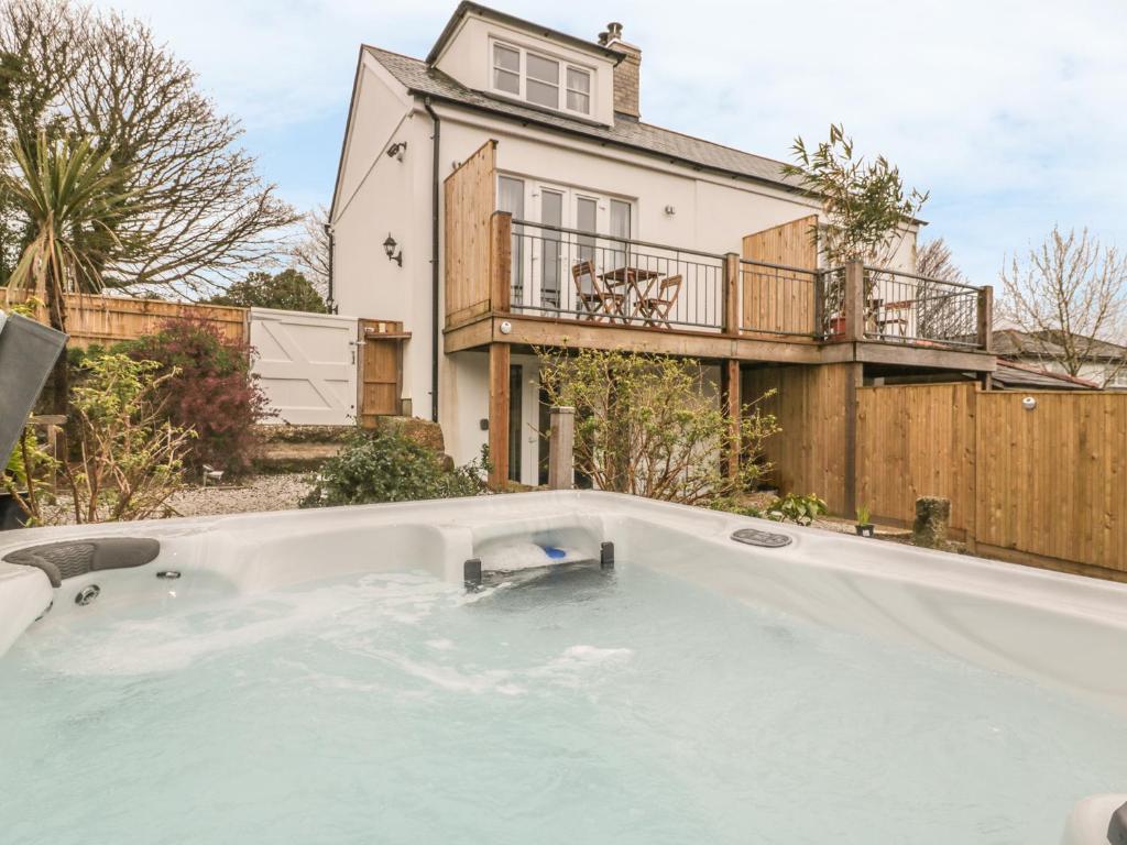 uma grande piscina em frente a uma casa em Crift Farm Cottage em Bodmin