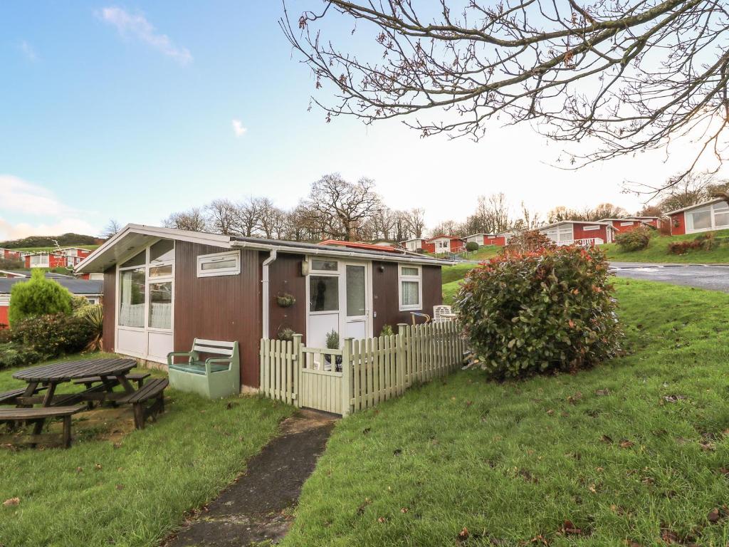 a small house with a picnic table in a yard at Willow 80 in Carmarthen