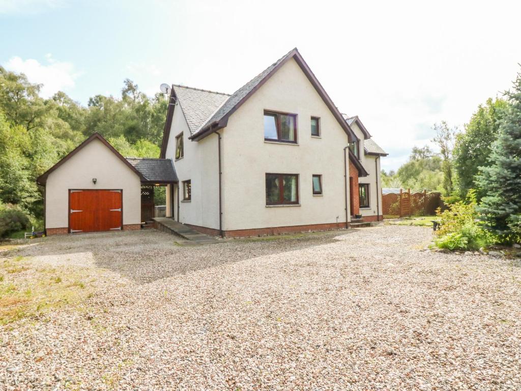 a house with a driveway in front of it at Riverbank House in Roybridge