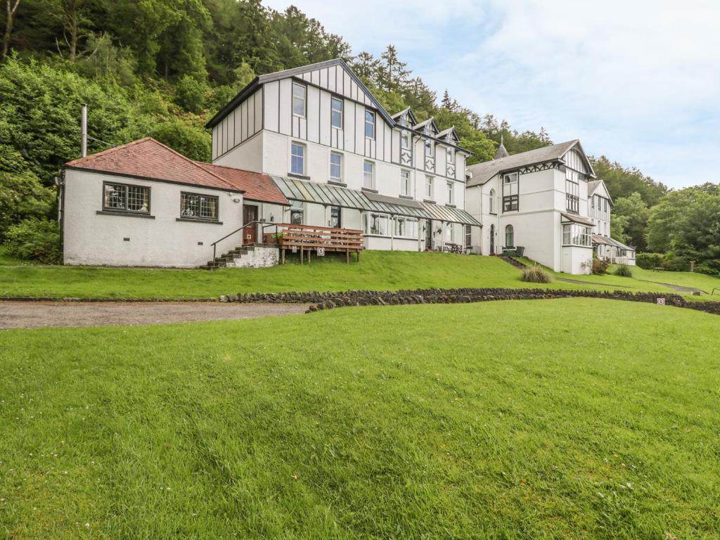 a large white building on a hill with a grass field at 2 Kilmun Court in Dunoon