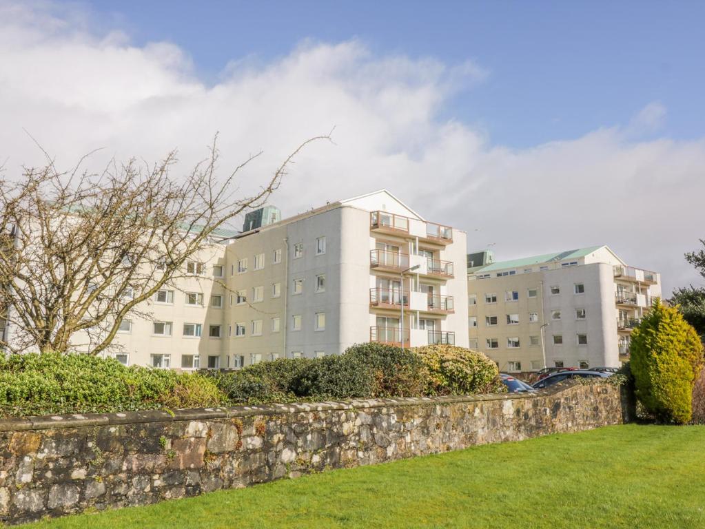 a stone wall in front of a building at Cumbrae View in Largs