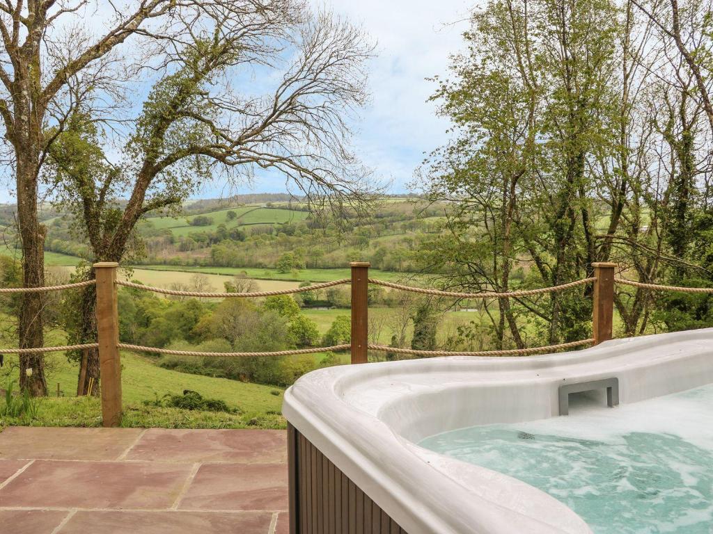 a hot tub with a view of a field at Little Silver Leaf in High Bickington