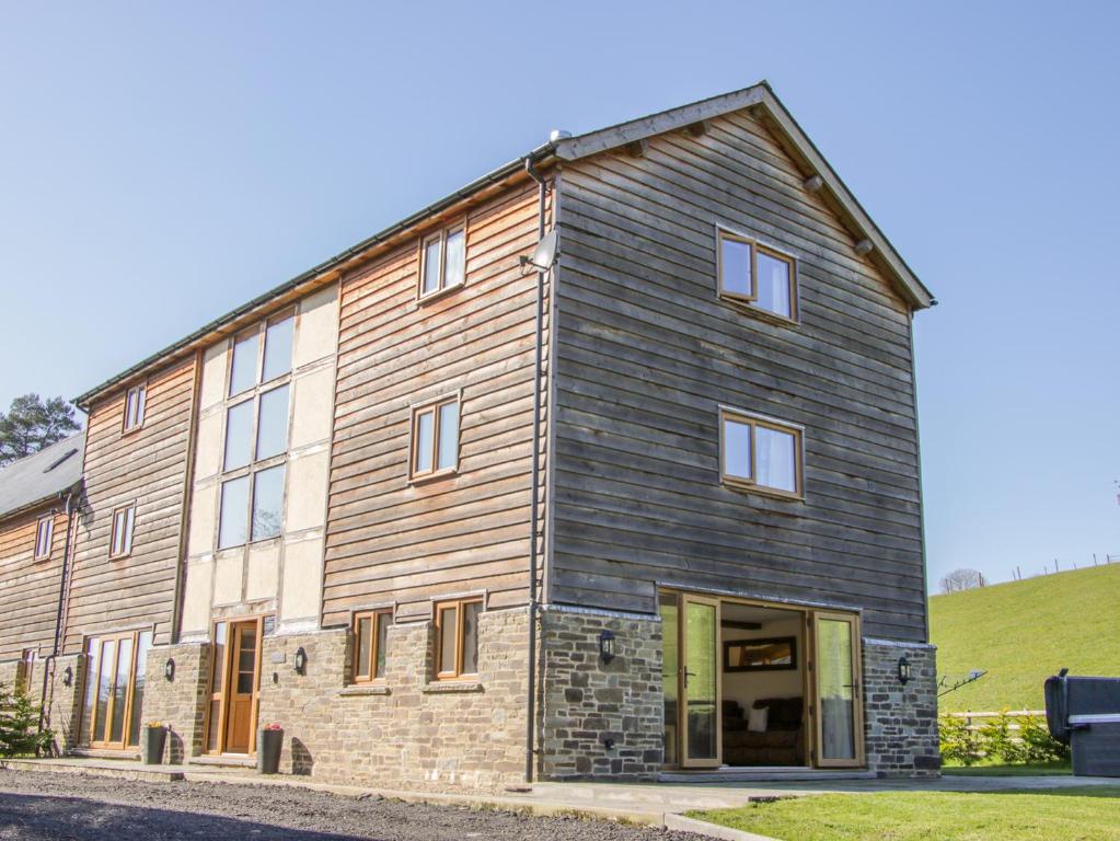 a barn style building with wooden siding at The Stables in Knighton