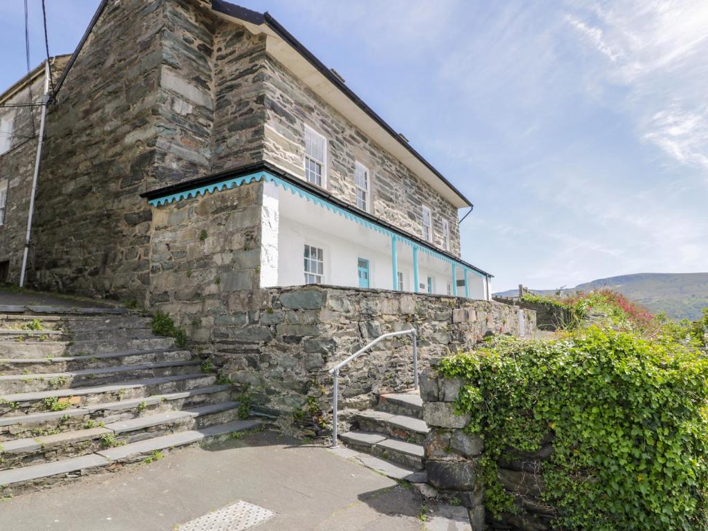 a stone building with stairs leading up to it at Goronwy Cottage in Barmouth