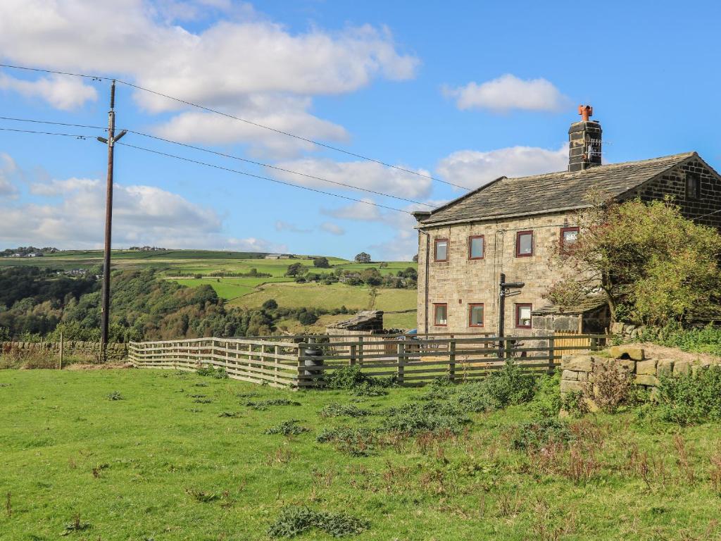 an old house in the middle of a field at 1 Horsehold Cottage in Hebden Bridge