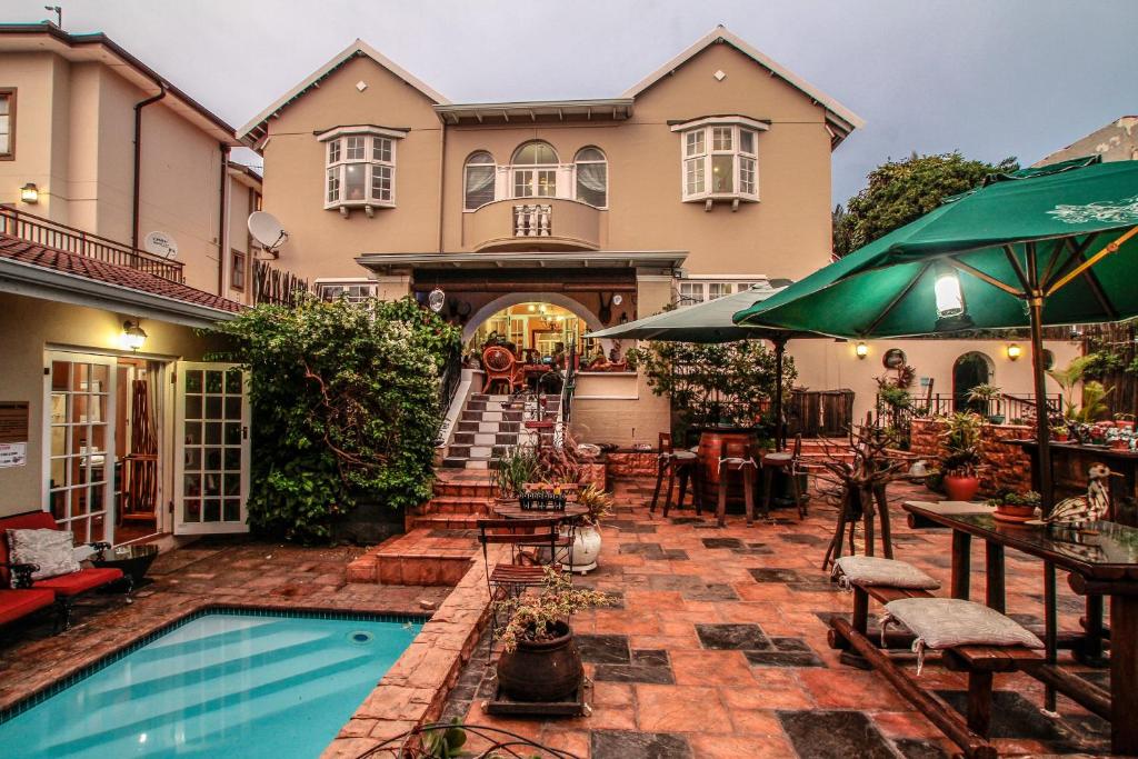 a house with a swimming pool and a patio at Acorn B&B in Durban