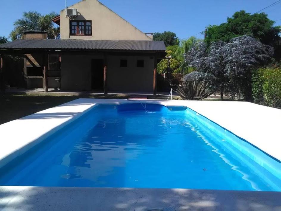 una piscina azul frente a una casa en Casa Loft Rumipal en Villa Rumipal