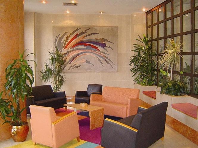 A colorful lounge seating area arranged beneath a large abstract painting.