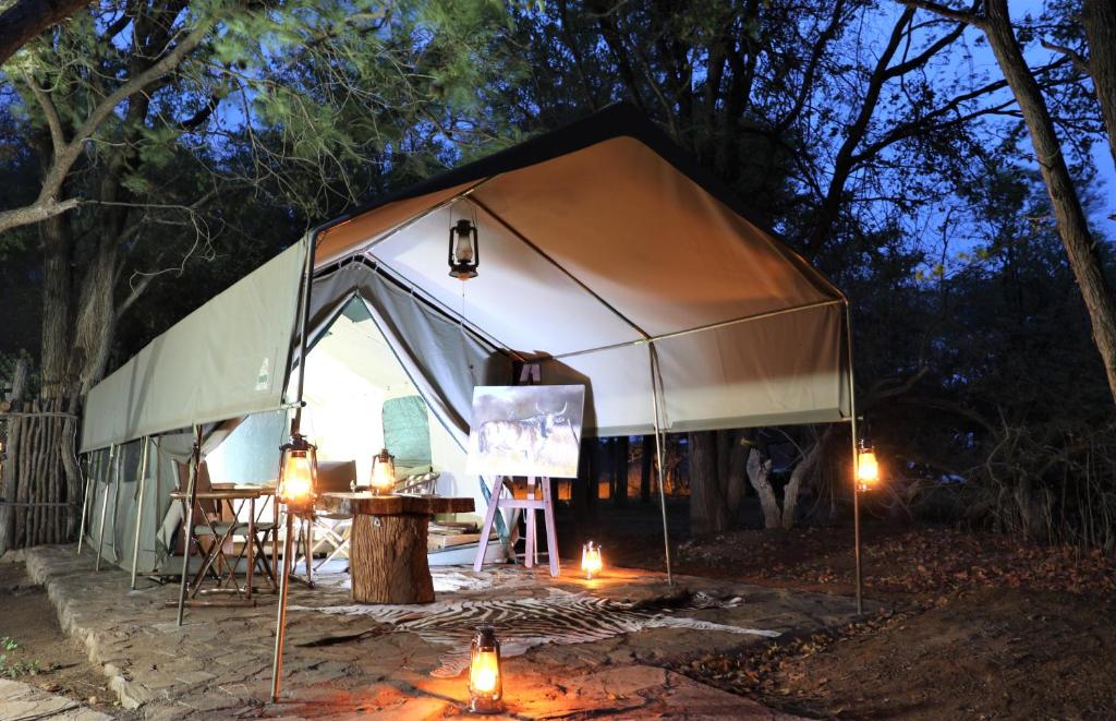 Sable Creek Safari Lodge في تزانين: خيمة فيها طاولة وشموع