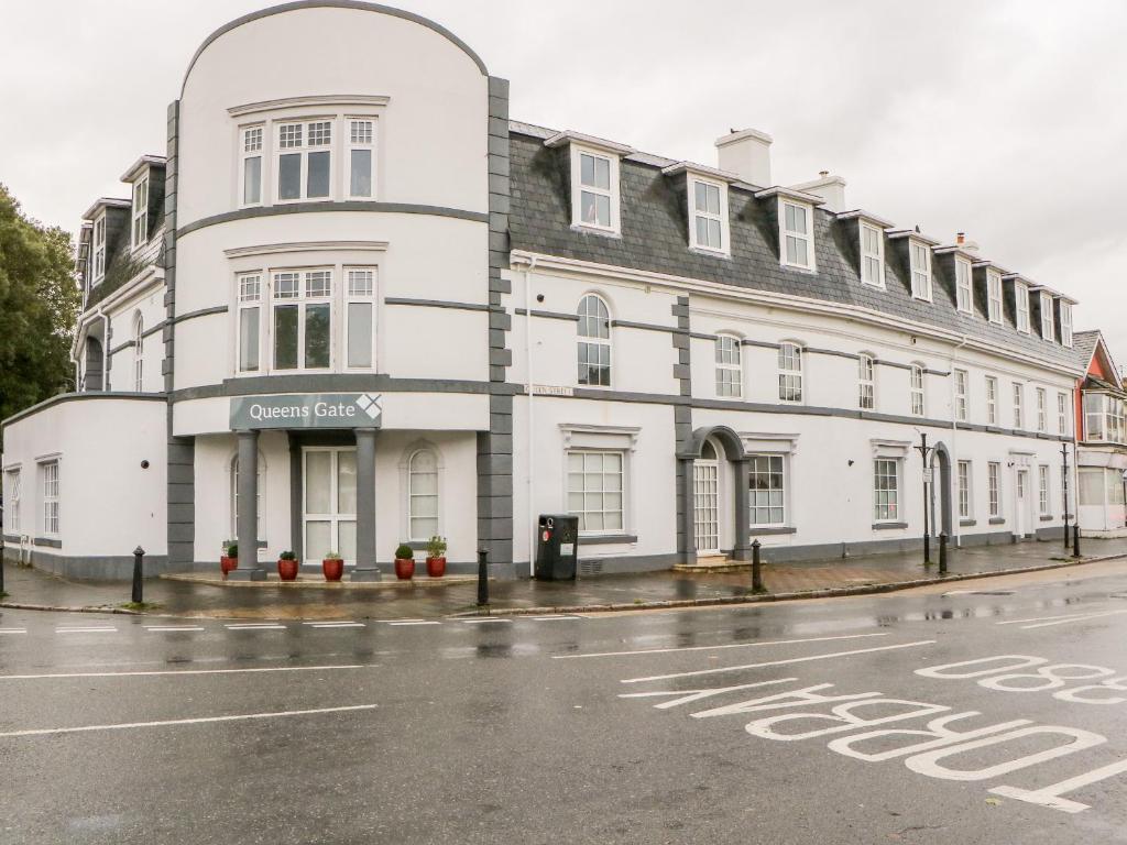 a white building on the corner of a street at Apartment 18 in Newton Abbot