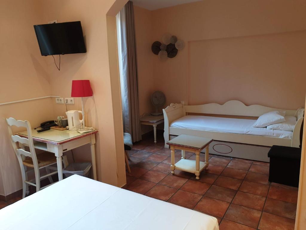 
a bedroom with a bed and a television at Hôtel Bonaparte in Toulon
