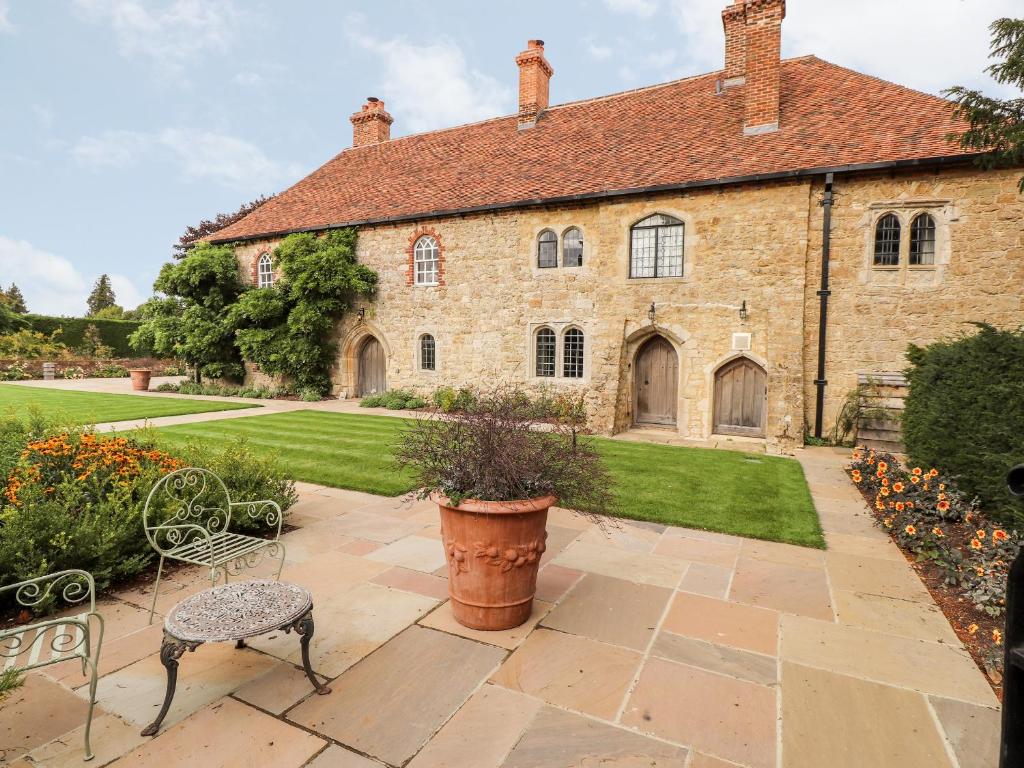 an exterior view of a large stone house with a patio at Battel Hall in Maidstone