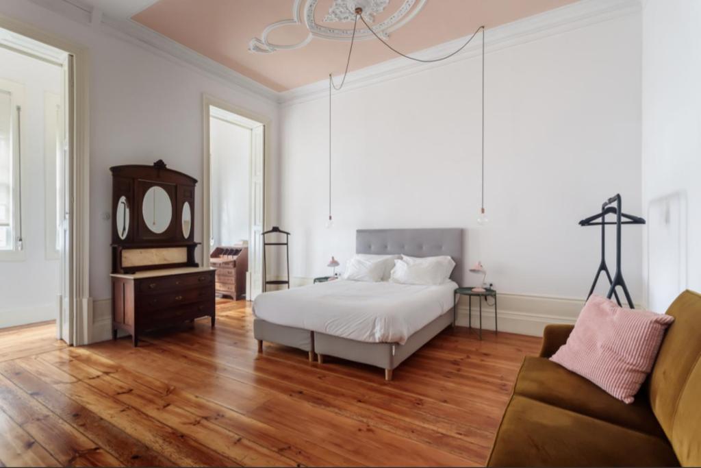 sypialnia z łóżkiem, lustrem i kanapą w obiekcie O da Joana w Porto