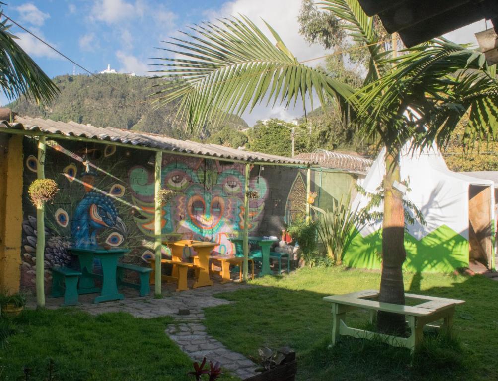 a house with a palm tree in the yard at Ulucaho Hostel in Bogotá