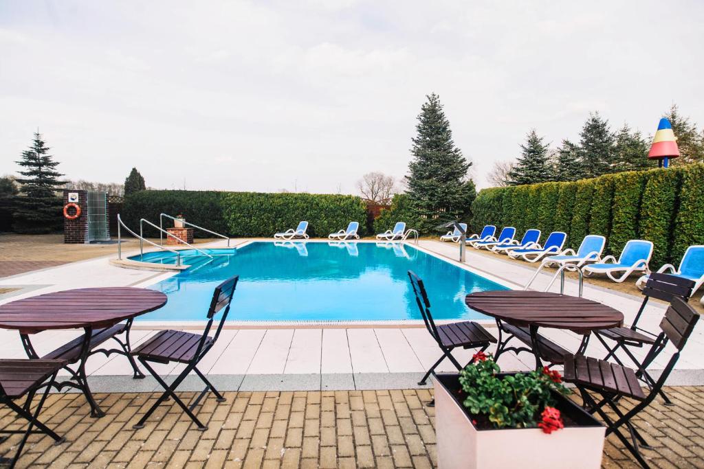 a swimming pool with chairs and a table and a table and chairs at DW Airen in Trzęsacz