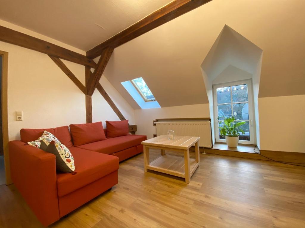een woonkamer met een rode bank en een tafel bij Zur Lutherkanzel in Jena