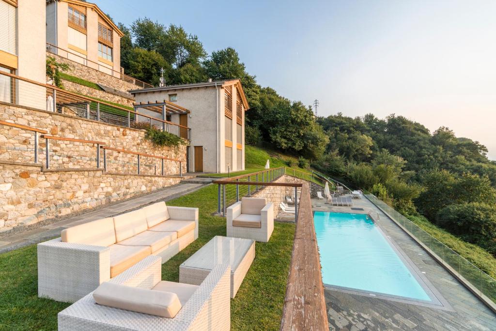 een villa met een zwembad en een gebouw bij beautiful poolside and stunning lake view Gardenia in Bellano