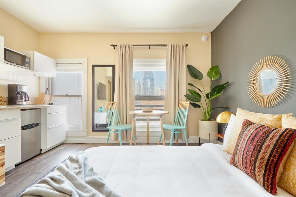 1 dormitorio con 1 cama y 1 mesa con sillas en Kasa Gaslamp Quarter San Diego, en San Diego