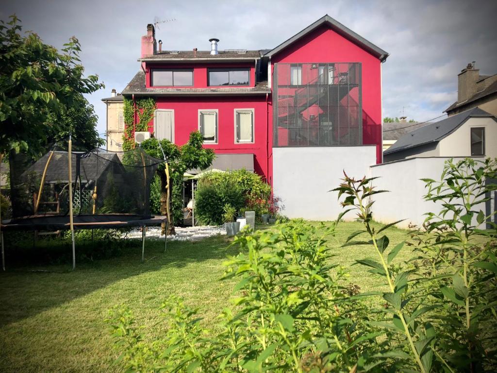 une maison rouge et blanche avec une cour dans l'établissement RESIDENCE AUX DEUX PICS - Tucou et Monné, à Bagnères-de-Bigorre