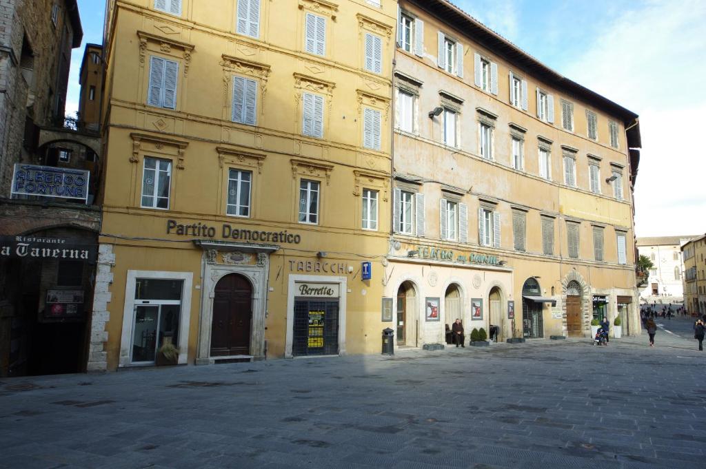 a large yellow building on a street in a city at Vannucci House in Perugia