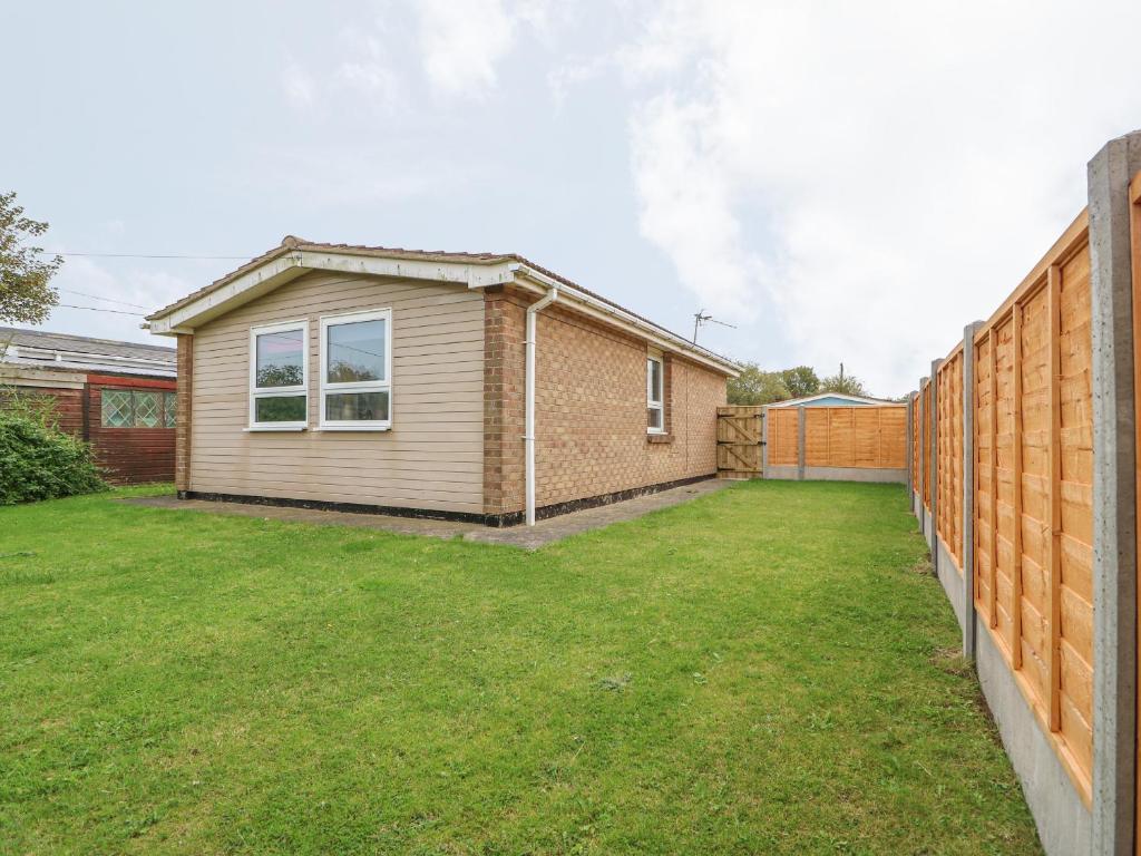 a backyard with a house and a fence at Moggs Retreat in Skegness
