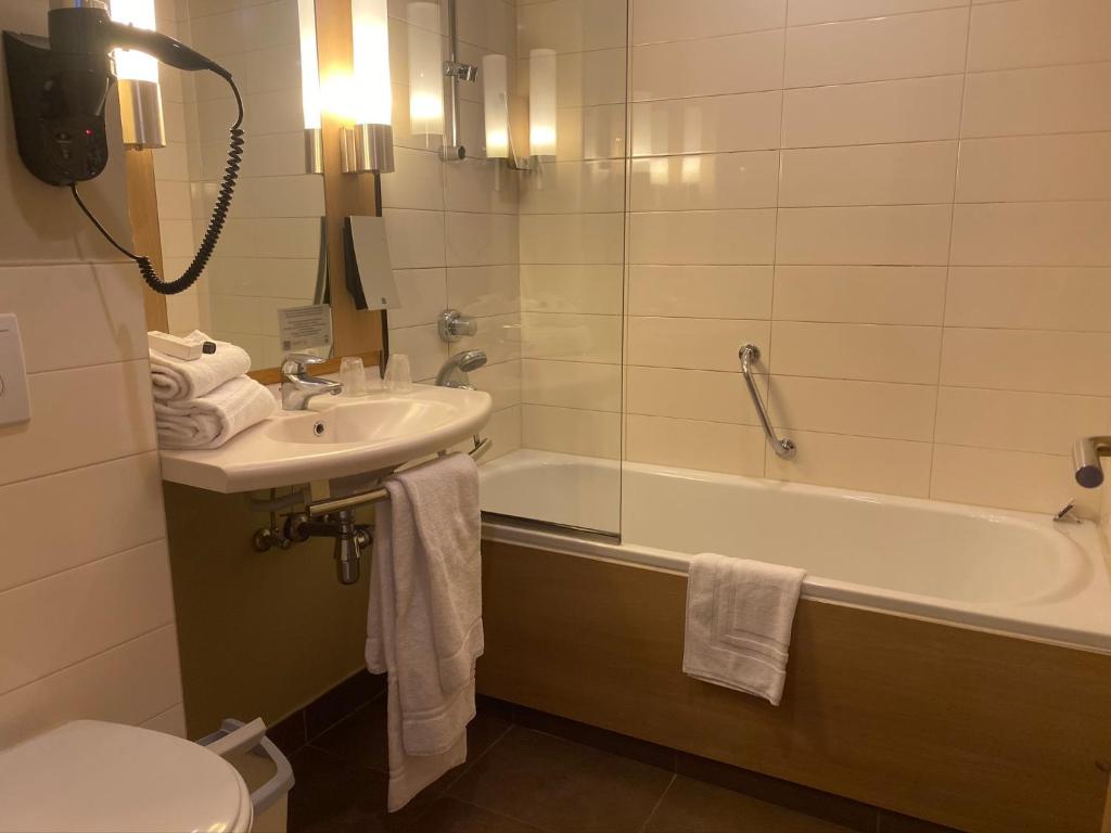 a bathroom with a sink and a tub and a toilet at Castel de Pont-a-Lesse in Dinant