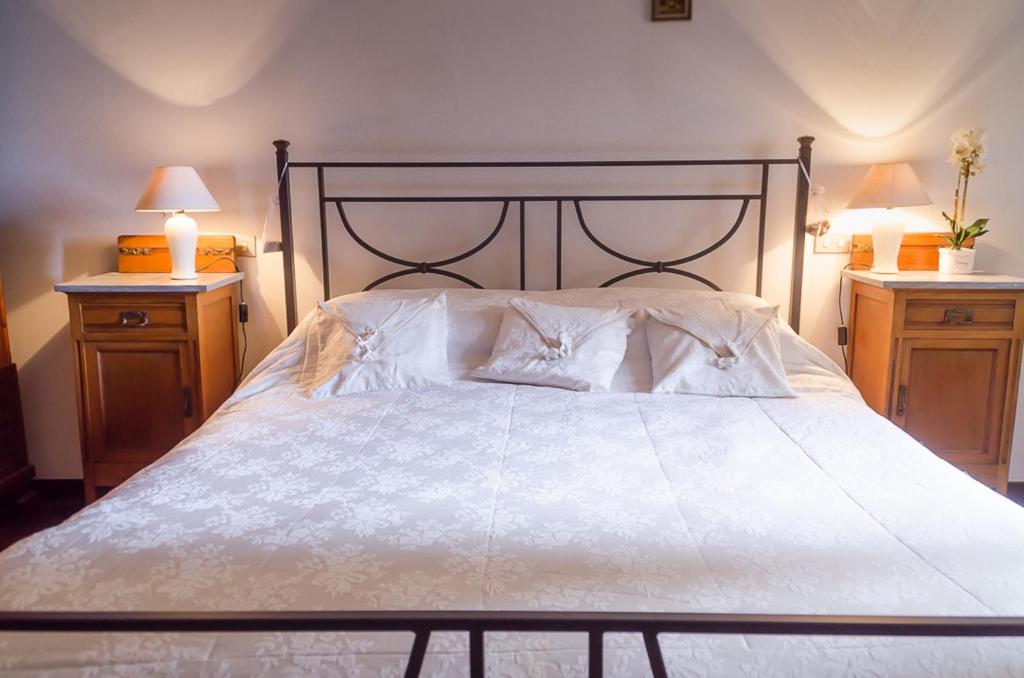 1 dormitorio con 1 cama blanca grande y 2 mesitas de noche en Danya Country Villa en Sansepolcro